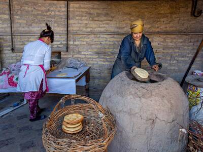 Uzbek women make tandoori bread in Uzbekistan
