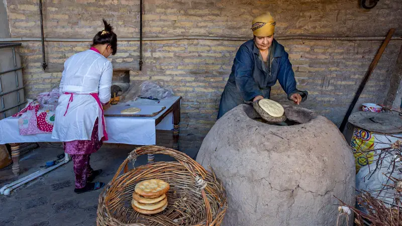 Uzbek women make tandoori bread in Uzbekistan